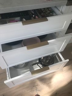 an open drawer with pots and pans in it