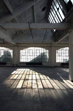 an empty warehouse with several windows and bars