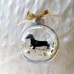 a glass ornament with a dachshund on it's side