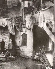 an old black and white photo of people hanging out to dry