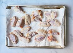 raw chicken pieces on a baking sheet ready to be put in the oven for roasting