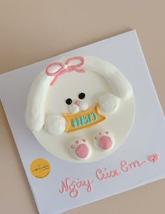 a white cake with pink and yellow decorations on it that says hey, mary cat emo