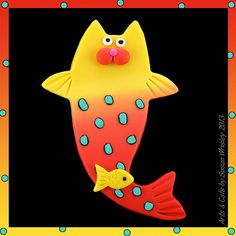 a yellow and red fish with blue dots on it's body is in the shape of a cat