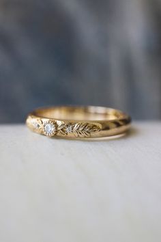 two gold wedding rings sitting on top of each other