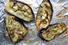 four baked eggplant halves on aluminum foil