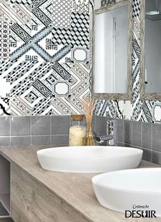 two white sinks sitting next to each other on top of a wooden counter in front of a mirror