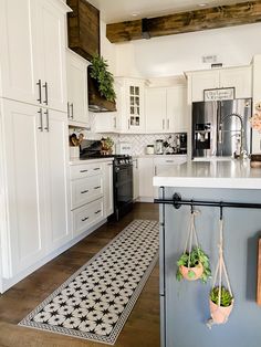 a kitchen with white cabinets and black and white tile flooring on the countertops