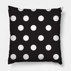 a black pillow with white polka dots on it