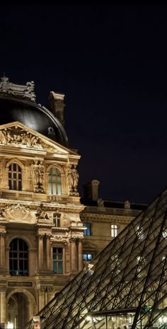 the building is lit up at night with lights on it's roof and windows