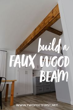 a kitchen with white cabinets and wood beams on the ceiling is featured in an article about how to build a faux wood beam