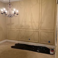 a chandelier hanging from the ceiling in a room with beige walls and carpet