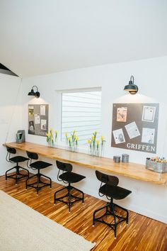 a long table with four stools in front of it on a hard wood floor