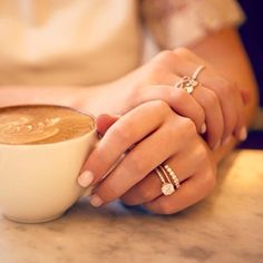 two people holding hands over a cup of coffee