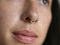 a close up of a woman's nose with a nose ring on her nose