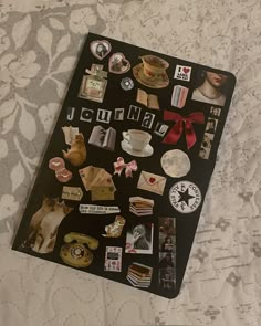 a book with pictures and magnets on it sitting on top of a white bed