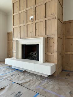 a fireplace is being installed in the middle of a room with wood paneling on the walls