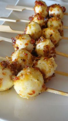 several skewered food items on a white plate