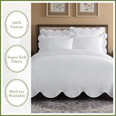 a white bed with scalloped ruffles on it and two framed pictures