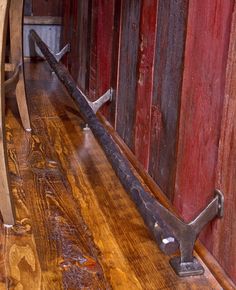 an old pair of tongs sitting on top of a wooden floor next to a red wall