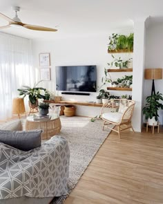 a living room filled with furniture and a flat screen tv sitting on top of a wooden floor