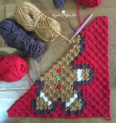 a crocheted christmas stocking with yarn and balls of yarn next to it