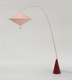 a floor lamp with a pink shade on it