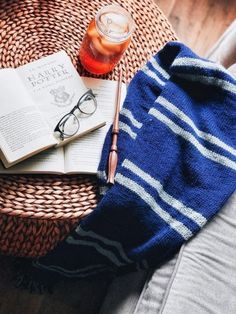 an open book and glasses on a wicker table