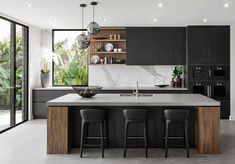 a modern kitchen with black cabinets and marble counter tops is seen in this image from the front view