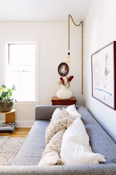 a living room filled with furniture and a clock on top of the wall above it