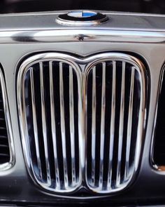 the front grille of a bmw car with chrome grills and blue emblem on it