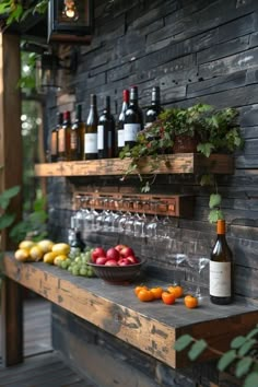 a wooden shelf filled with bottles and glasses next to fruit on top of a table