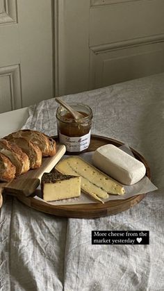 bread, cheese and jam are on a tray