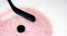 a black spoon sitting on top of a pink substance