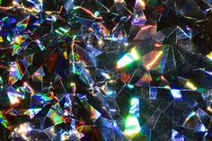 an abstract background consisting of many shiny pieces of glass with different colors and shapes on them