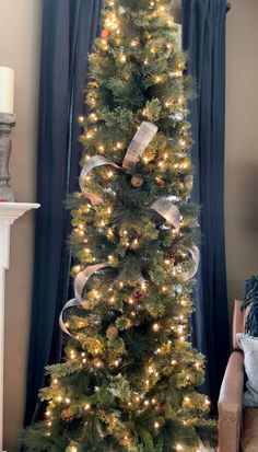 a christmas tree is decorated with lights and ribbons