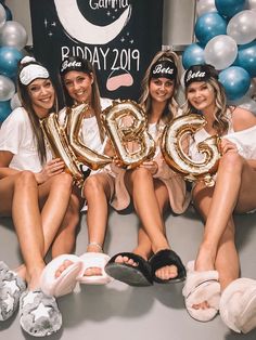 four women sitting on the floor holding up balloons in front of a sign that says glob