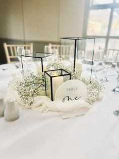 the table is set with white flowers and candles for an elegant centerpiece or decoration