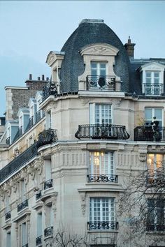 an apartment building with balconies and windows in paris, france at dusk time