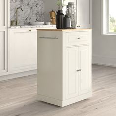 a kitchen with white cabinets and marble counter tops, along with an island in the middle