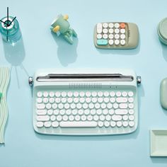 an old fashioned typewriter sitting on top of a blue table next to other office supplies