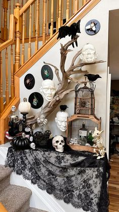 a table topped with black and white decorations next to a stair case filled with halloween items