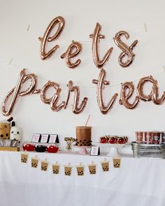 a party table with balloons and desserts on it