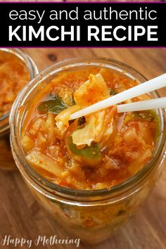 two glass jars filled with kimchi soup and chopsticks sticking out of them