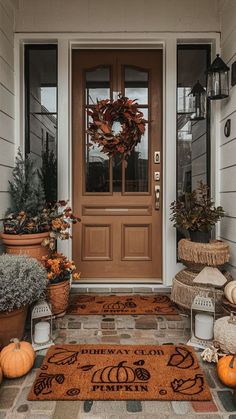 the front door is decorated with pumpkins and other decorations