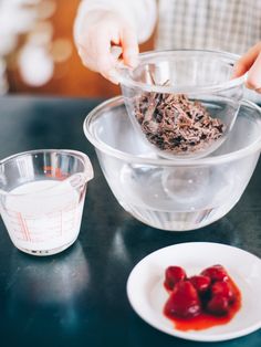 someone is mixing something in a bowl on a table with other ingredients and utensils