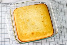 a cake in a glass baking dish on a cooling rack