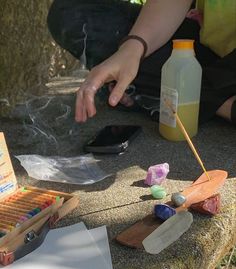 a person sitting on the ground next to an open box of crayons and glue