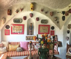 a living room filled with furniture and pictures on the wall