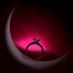 a diamond ring sitting on top of a crescent in the middle of a dark room