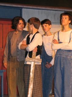 four young men standing next to each other